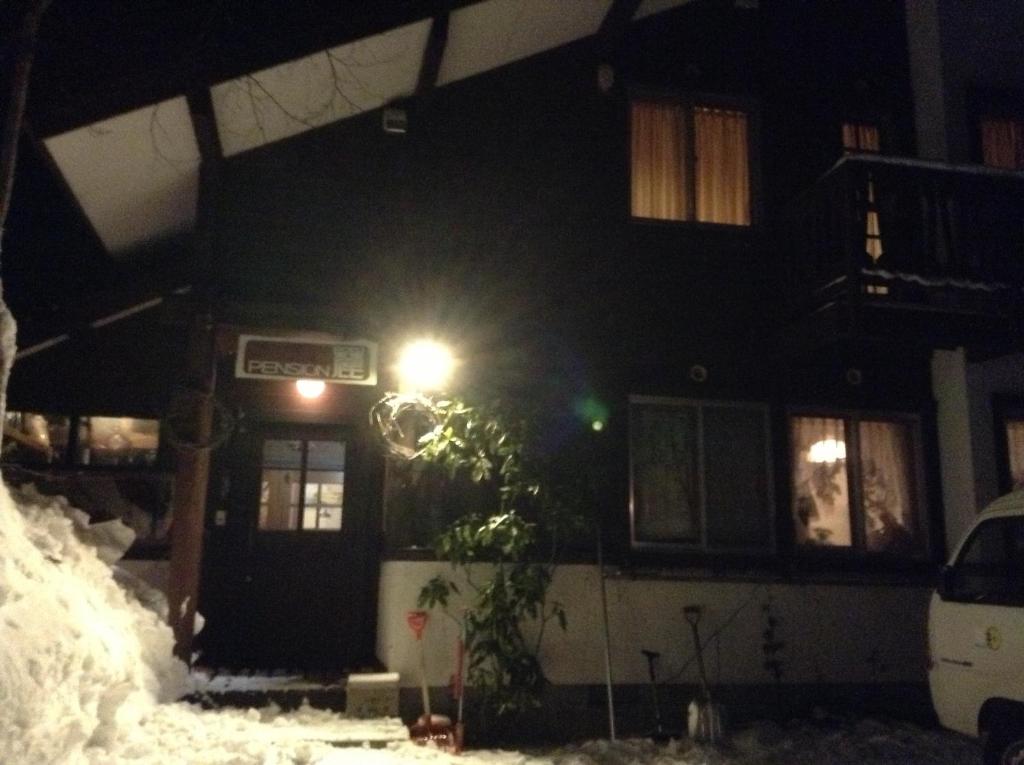 白马村洛库旅馆的夜晚雪中放着小街灯的房子