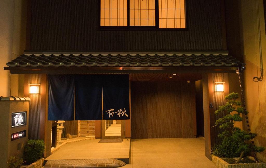大阪有秋酒店的带有蓝色窗帘的建筑物的前门