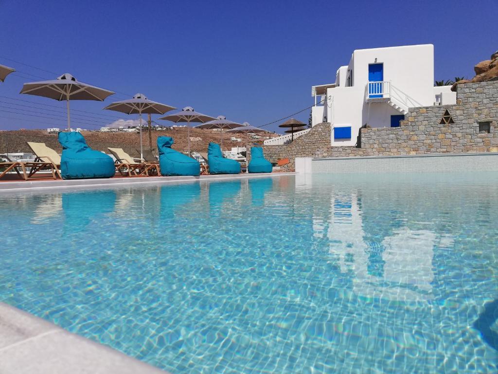 普拉迪斯亚罗斯佩拉格斯一室公寓酒店的一个带蓝色椅子和遮阳伞的大型游泳池