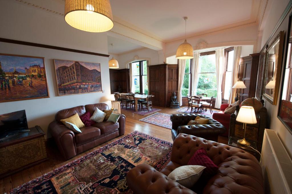 莫法特Warriston Apartment at Holm Park的一间带真皮沙发的客厅和一间带桌子的客厅