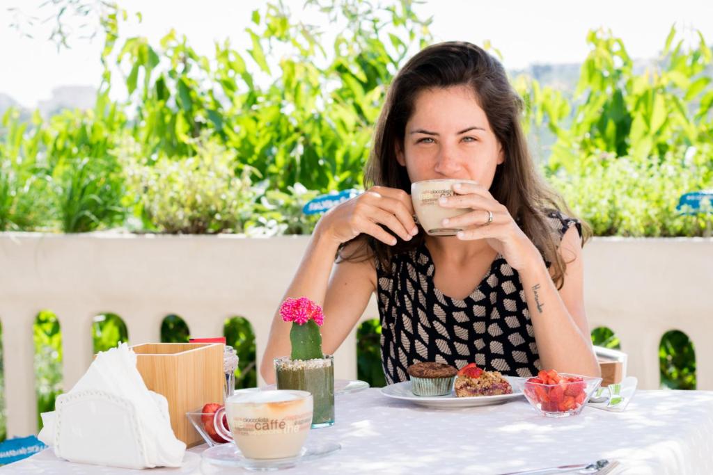 维耶斯泰星光灿烂花园住宿加早餐旅馆的坐在桌子上喝咖啡的女人