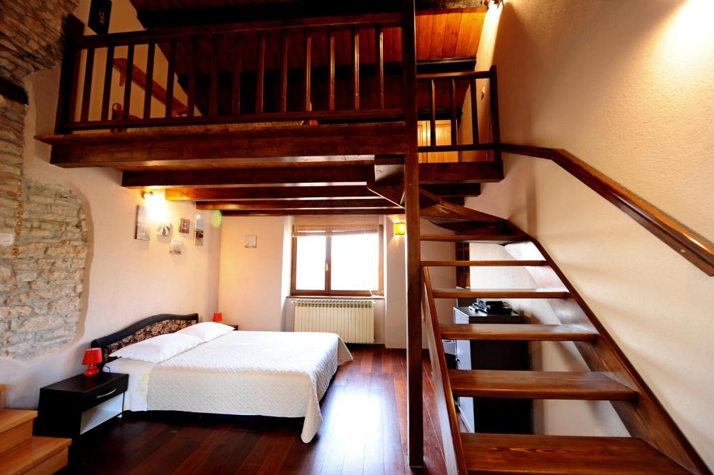 拉卡尔Apartment Paola的一间卧室设有一张床和一个螺旋楼梯