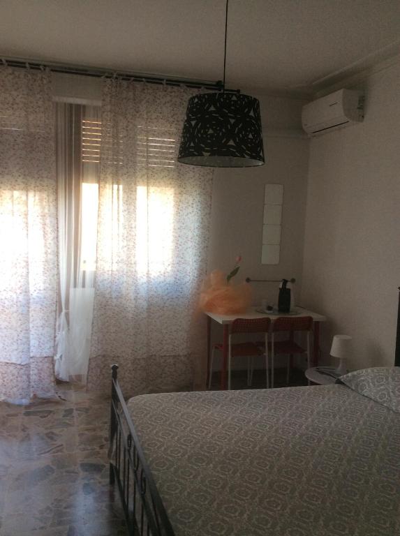 比萨朱利亚茵住宿加早餐旅馆的一间卧室配有一张床、一张桌子和一个窗户。