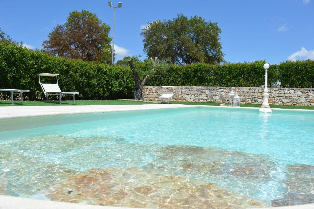 马丁纳弗兰卡Masseria Paglieroni的庭院内的游泳池,带椅子