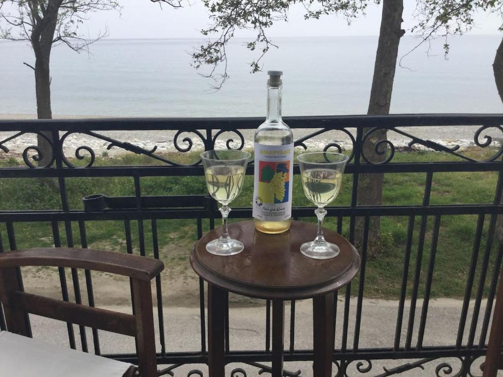 霍里顿Villa Chorefto的桌子上放有一瓶葡萄酒和两杯酒