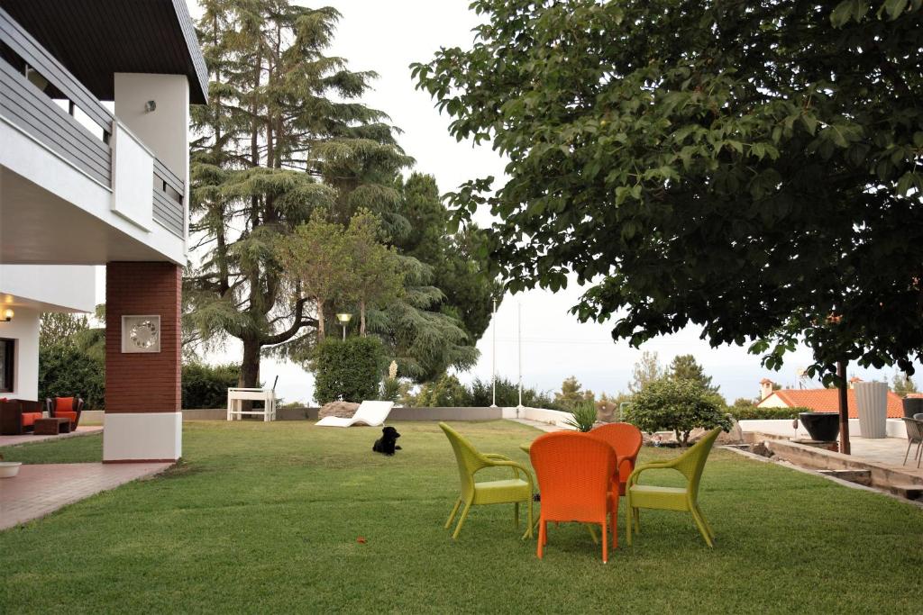 克里皮吉Artesiane apartments的坐在院子里草地上的一组椅子
