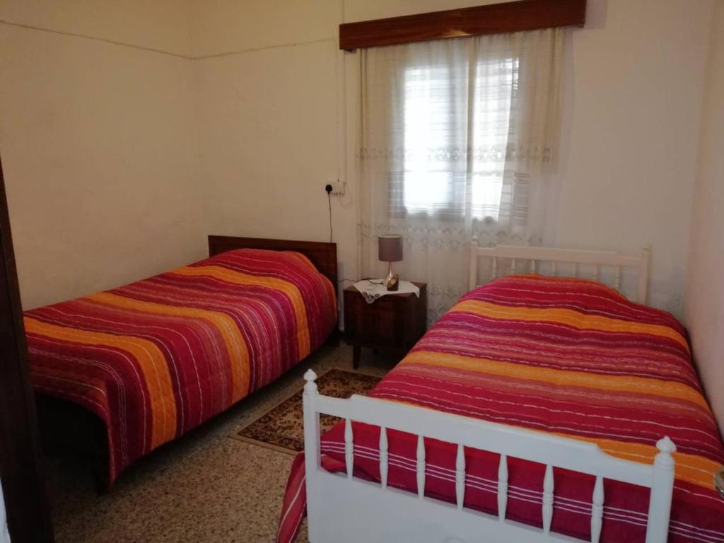 卡科佩特里亚克里斯托斯度假屋的一间卧室设有两张床和窗户。
