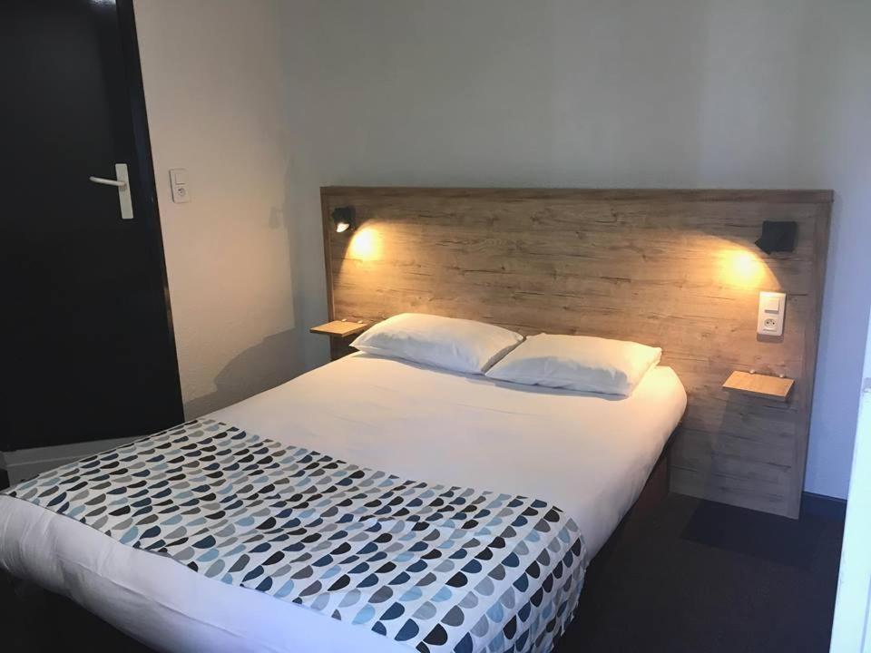 阿尔蒂盖普雷博尔多my HOTEL Bordeaux的一间卧室配有一张大床和木制床头板