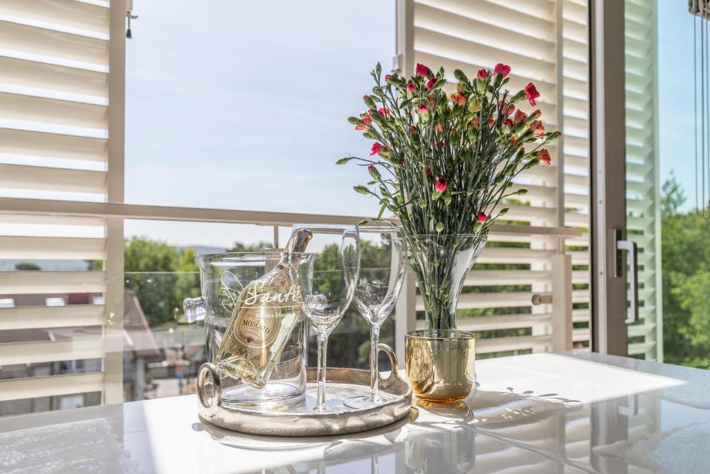 米兹多洛杰Apartament Prestige & Sea Playa Baltis 63的一张桌子,上面有酒杯和花瓶