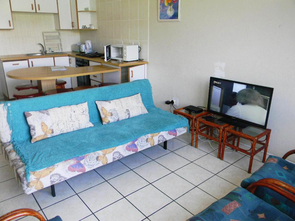 马盖特Dumela Margate Flat No 2的客厅配有蓝色的沙发和电视
