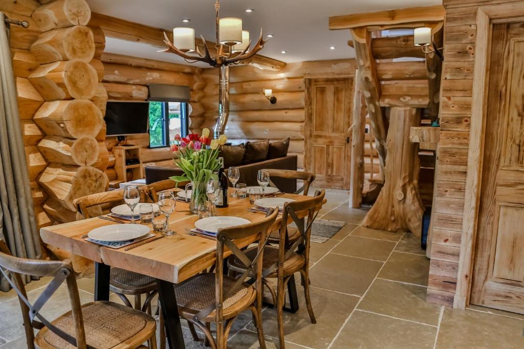阿维莫尔Cedar Lodge的一间带木桌和椅子的用餐室