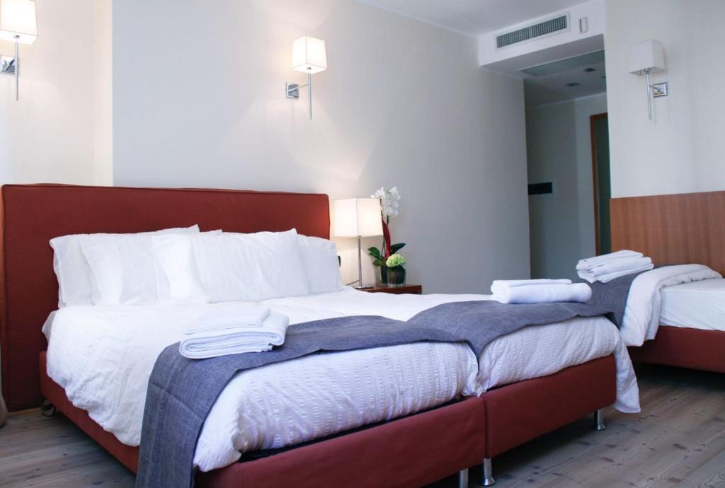 斯尔斯Antica Trattoria的两张位于酒店客房的床,配有毛巾