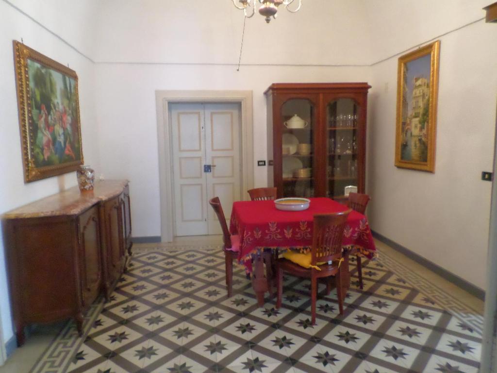 布林迪西Casa Millenovecento的一间用餐室,配有红色的桌子和椅子