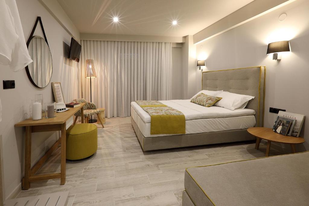 斯塔夫罗斯Kallini Apartments的配有一张床和一张书桌的酒店客房