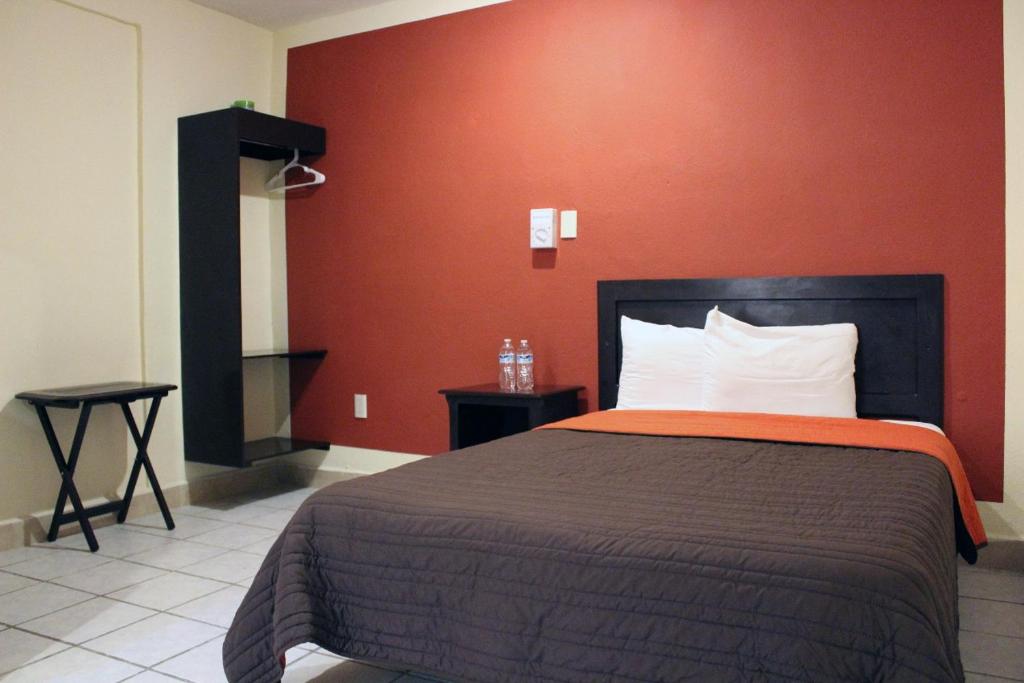 坎佩切Hotel Maya Becan的一间卧室配有一张红色墙壁的床