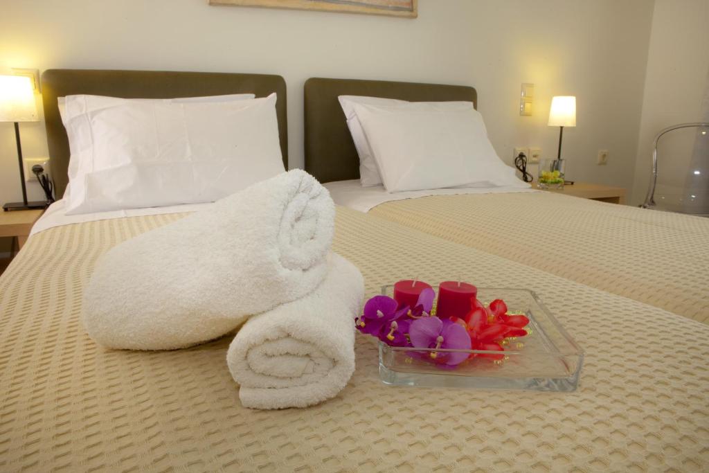 卢特拉艾季普苏伊利安Spa酒店的床上的白色毛巾和一碗鲜花