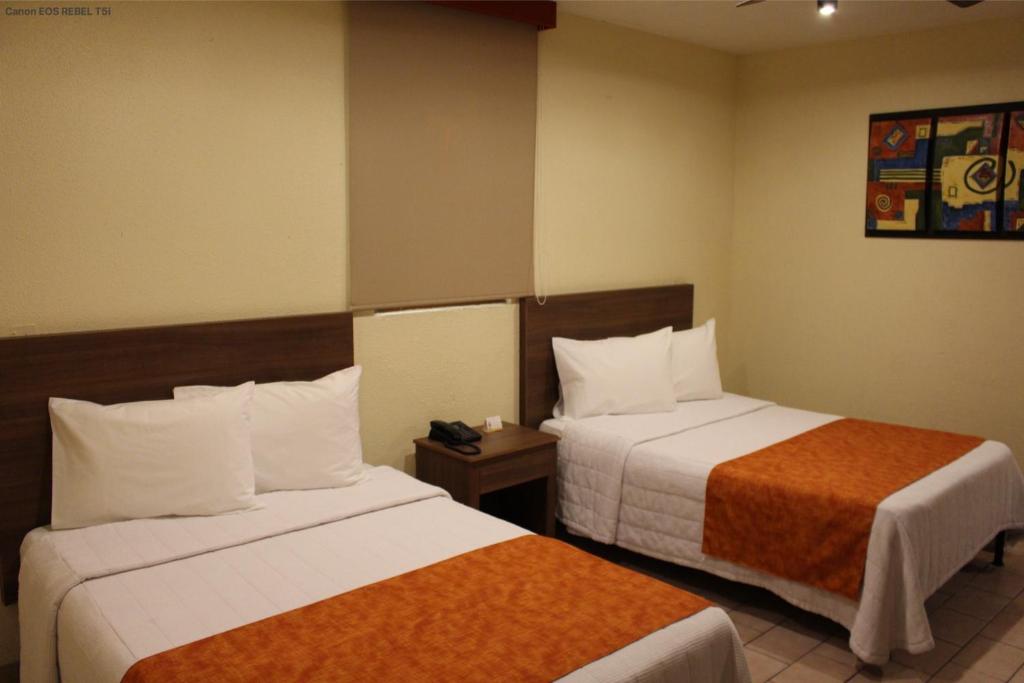 瓜达拉哈拉波萨达韦睿酒店的一间酒店客房,房间内设有两张床