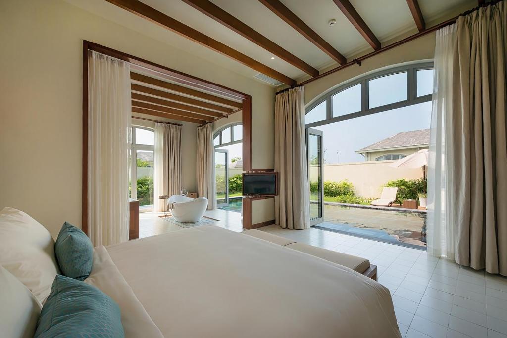 岑山FLC萨姆森豪华度假酒店的卧室设有白色的床和大窗户