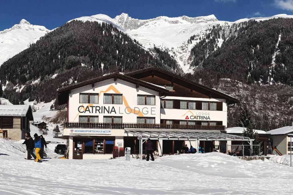 迪森蒂斯Catrina Lodge的雪地里的人一起入住滑雪小屋