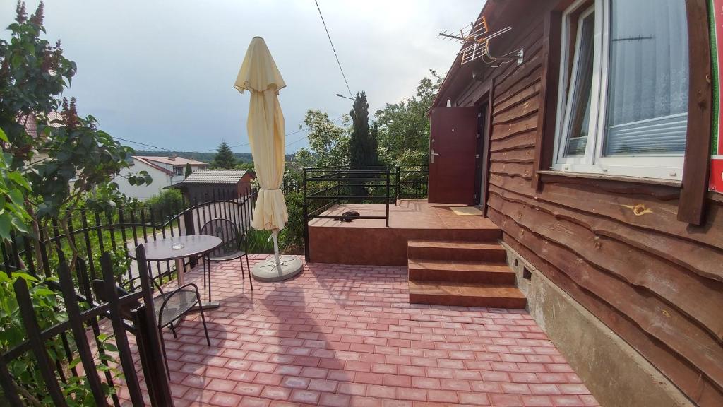 Zagnańsk绿色隐居民宿的房屋内带桌子和遮阳伞的天井