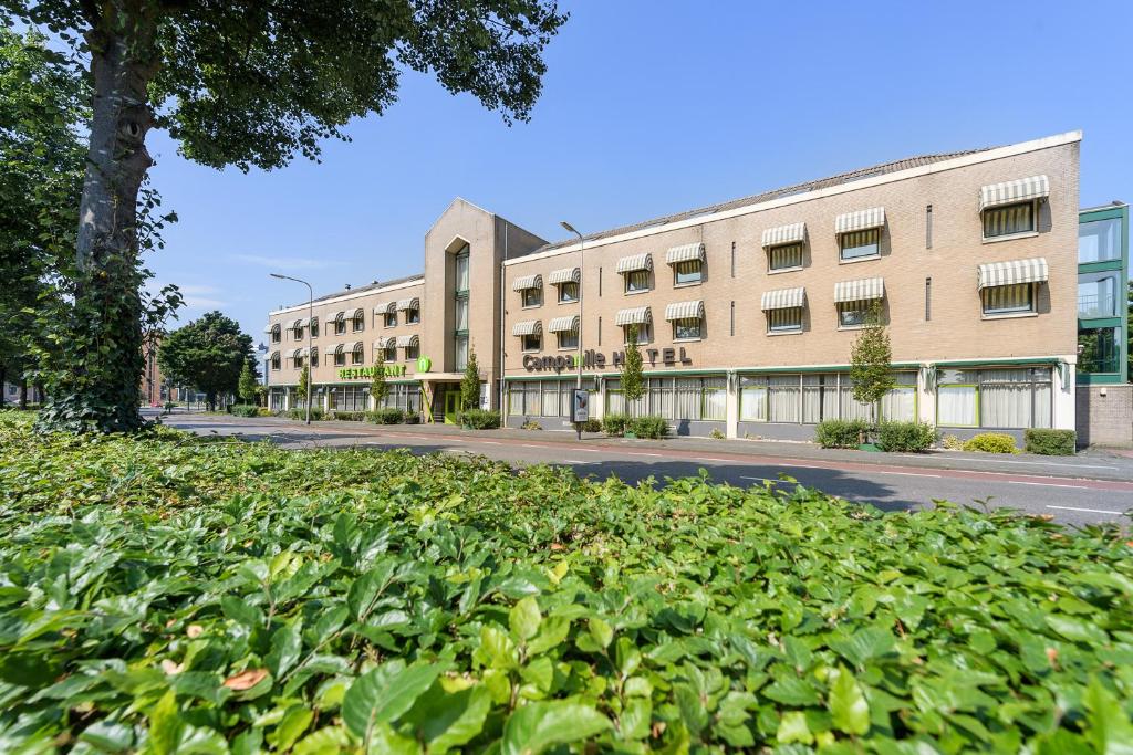 兹沃勒兹沃勒钟楼酒店及餐厅的前面有大量植物的建筑