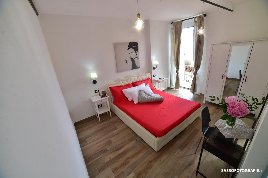 瓦里格提Suite Varigotti的一间卧室配有红色的床和镜子