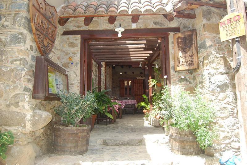 卡科佩特里亚利诺斯酒店的石头建筑的入口,有盆栽植物