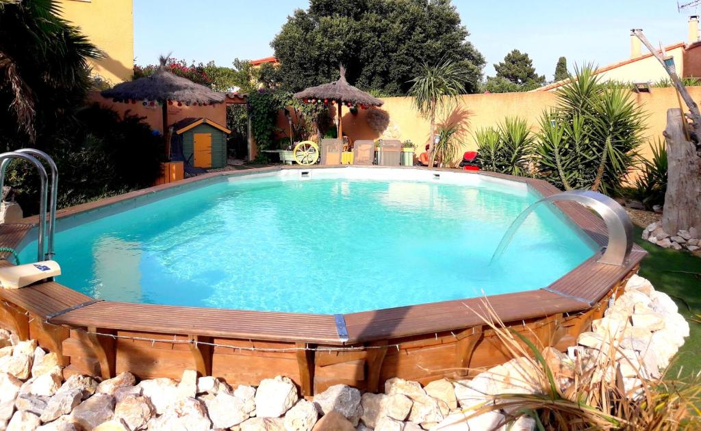 滨海阿热莱斯吉特圣朱利安度假屋的一座大型游泳池,四周环绕着木板凳