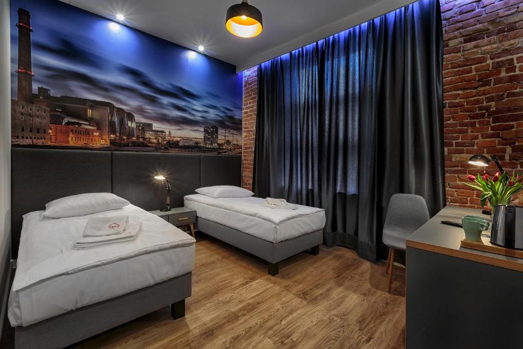 罗兹ADLER Bed&Breakfast的一间卧室设有两张床和砖墙