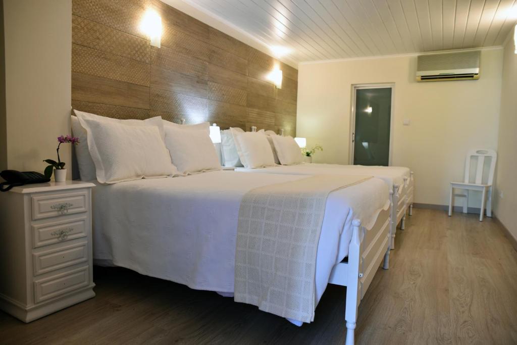 波尔图Hotel Visconde的卧室配有带白色枕头的大床