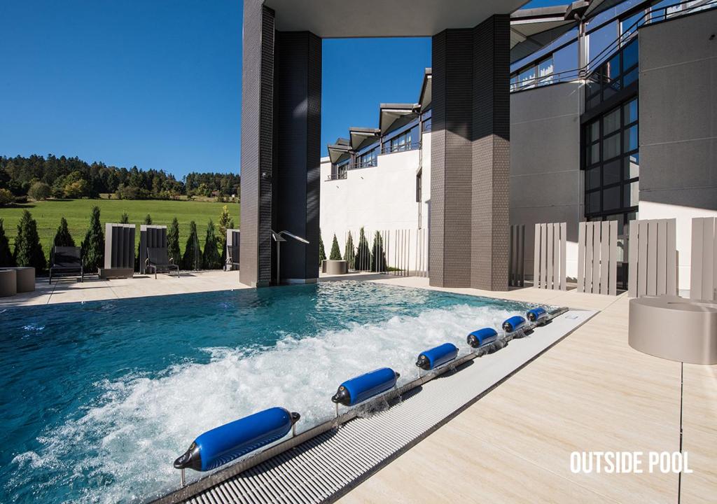 拉绍德封勒安德瑞兹大酒店的大楼内带蓝色躺椅的游泳池