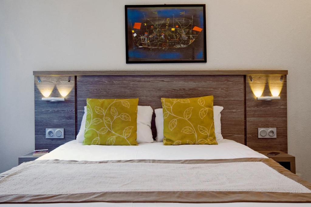 克莱蒙费朗塞祖尔阿菲尔克雷蒙费兰德共和公园酒店的一间卧室配有一张带黄色枕头的大床