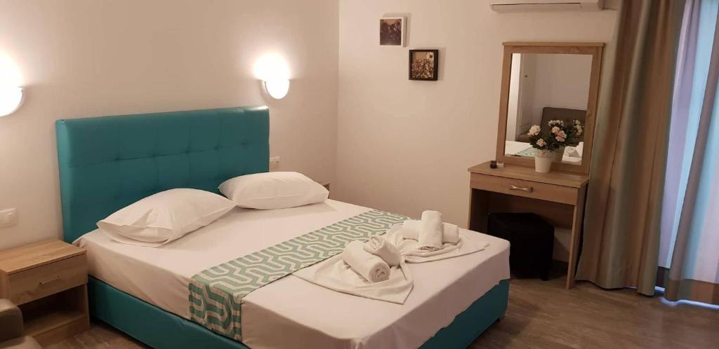 波罗斯Cielo Apartments的一间卧室配有一张带蓝色床头板和镜子的床