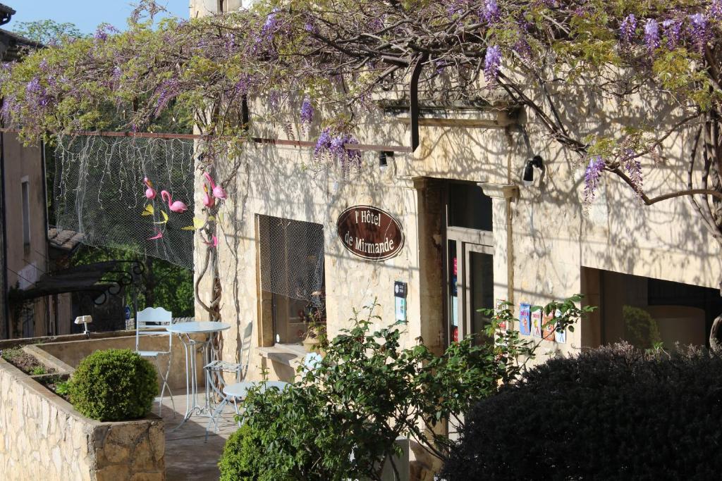米尔芒德米曼德酒店的石头建筑,带桌子和紫色花