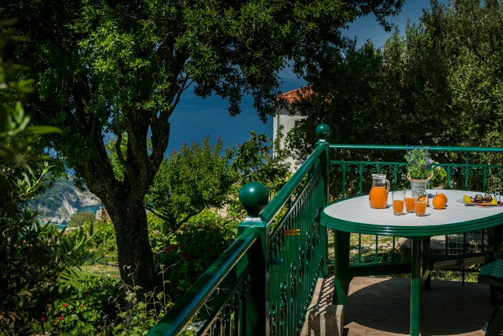 AnomeriáApartment Voula Myrtos的阳台上的桌子上放着橙汁