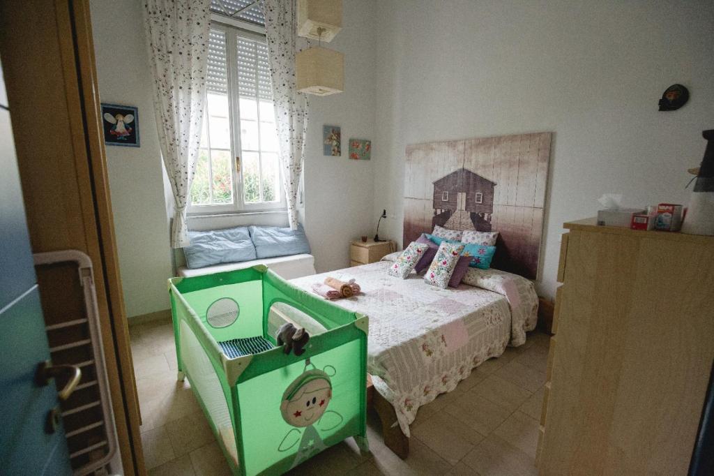 蒂勒尼亚Sea beach relax的儿童卧室设有一张绿色的床和一个窗户