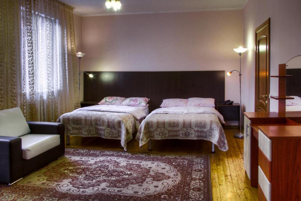 阿拉木图萨多瓦娅酒店的酒店客房,设有两张床和一张沙发