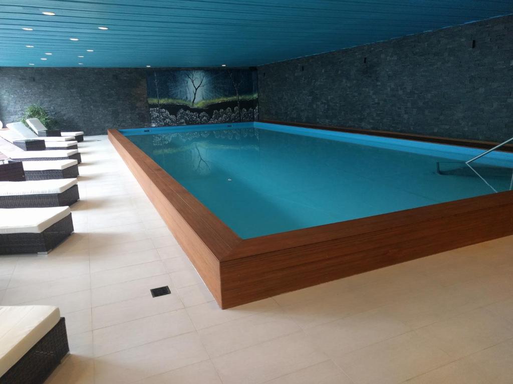 达沃斯Holiday accommodation - swimming pool available的一个带椅子的房间的大型游泳池