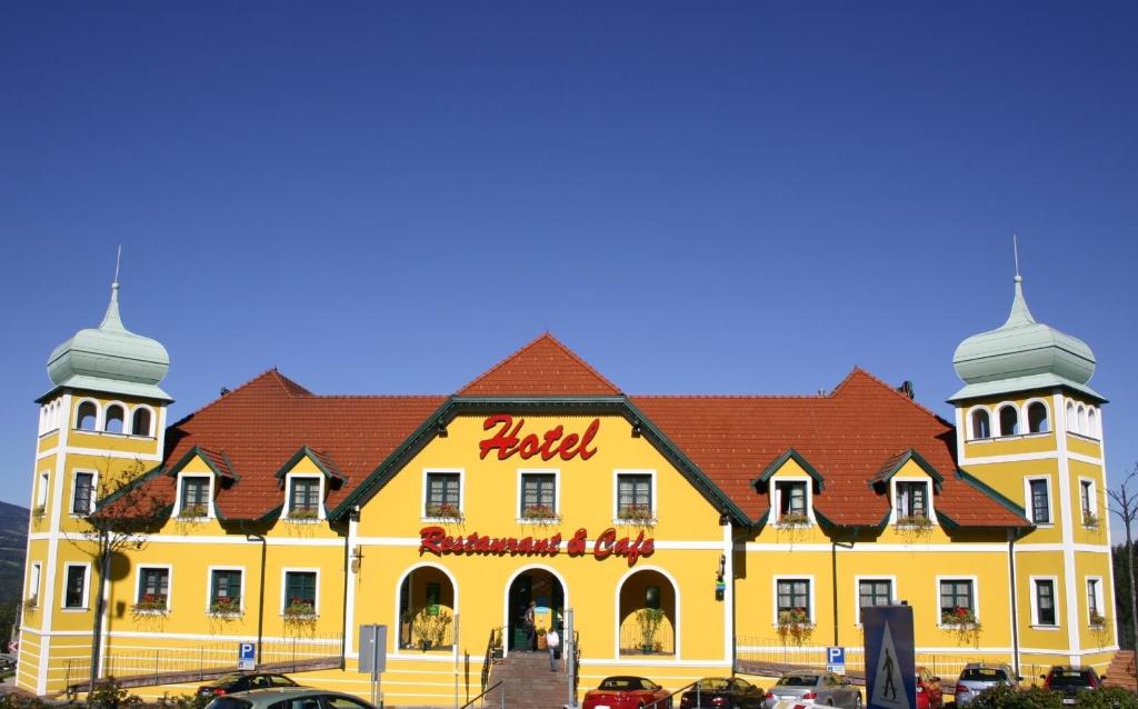 ZöbernAutobahnrestaurant & Motorhotel Zöbern的一座黄色的大建筑,上面有酒店标志