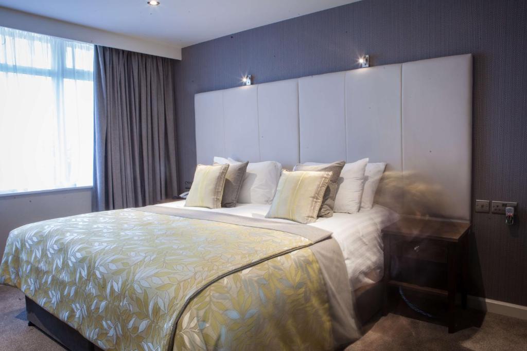 莫纳汉四季酒店及休闲俱乐部的卧室配有一张带白色床单和枕头的大床。