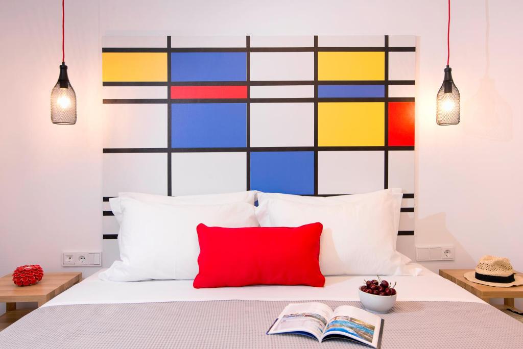 波托什Cozy Suites的卧室配有红色枕头和色彩缤纷的墙壁