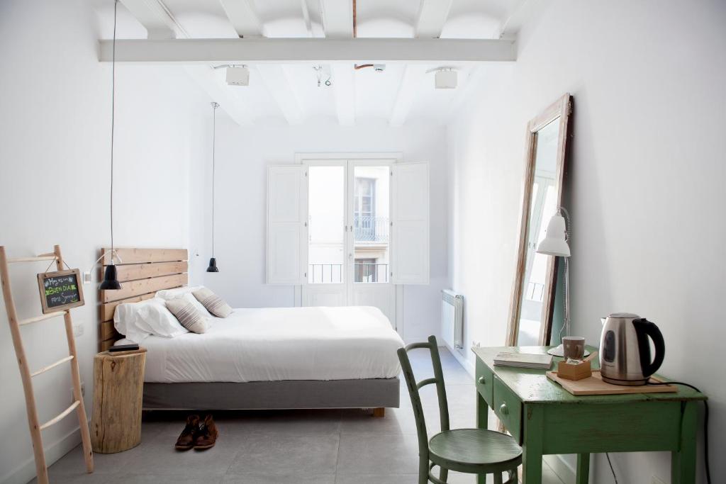 巴塞罗那格劳生态精品酒店的一间卧室配有一张床、一张桌子和一张书桌