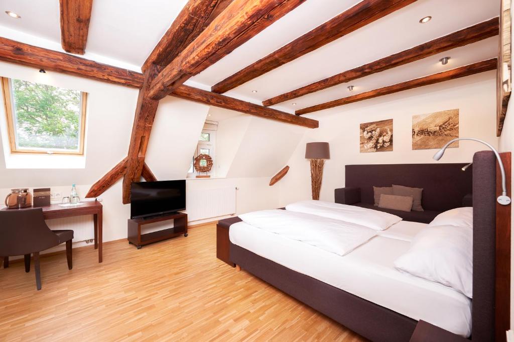 施韦比施哈尔利霸布鲁酒店的卧室配有一张白色大床和一张书桌