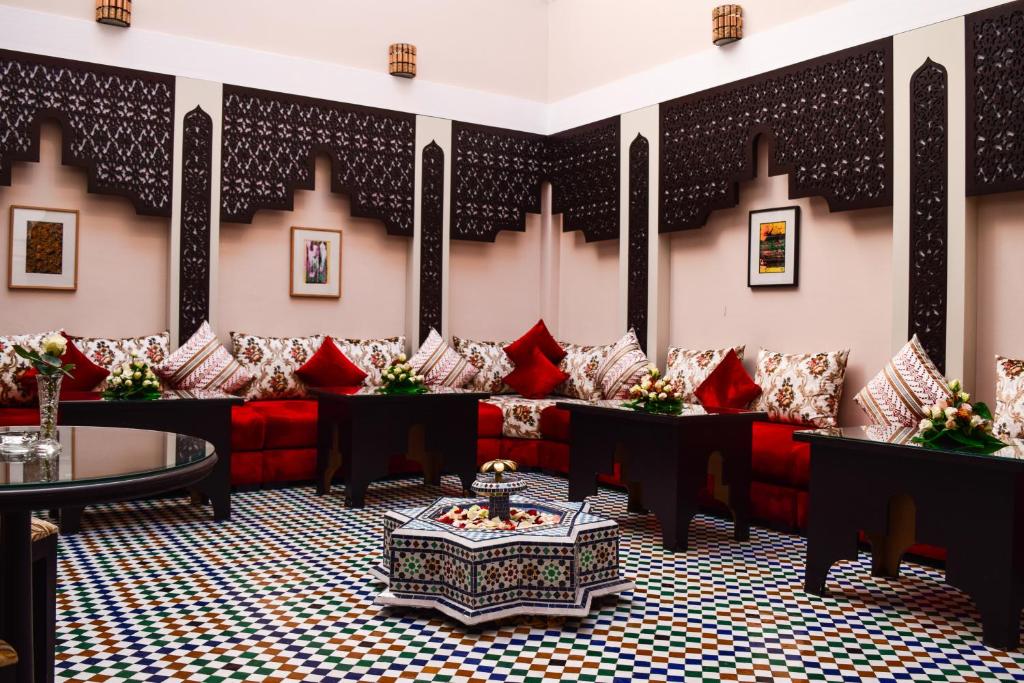 马拉喀什Riad Zaki的大堂设有红色的沙发和红色的枕头