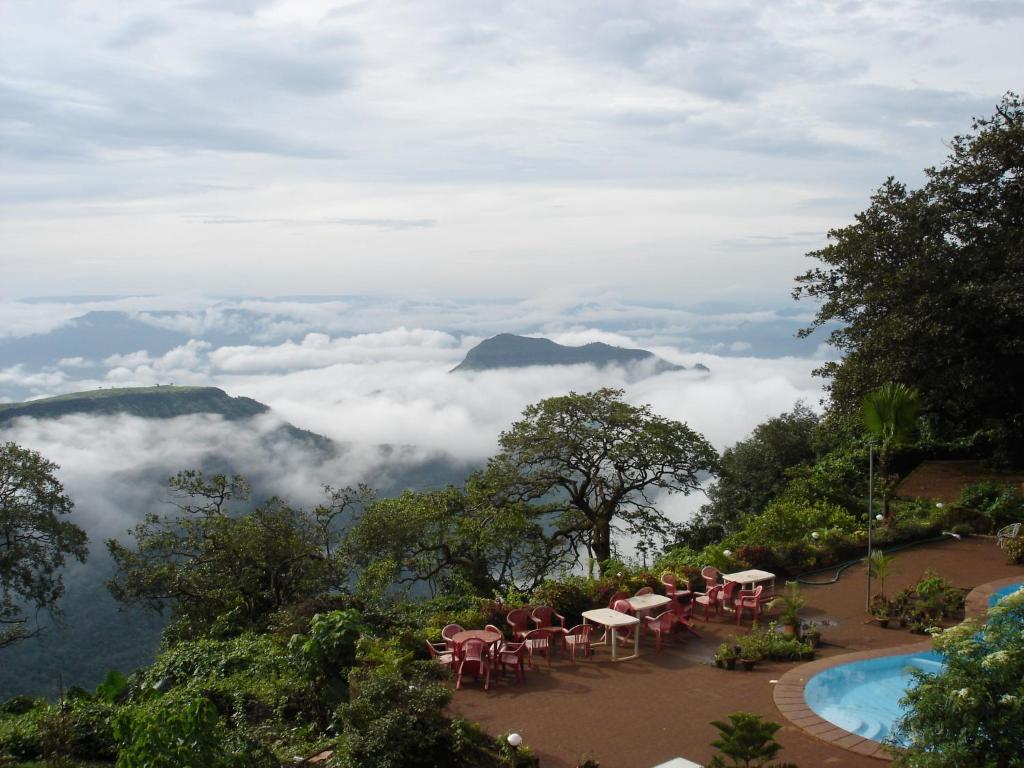 马泰兰Lords Central Hotel的餐厅享有山脉和云层的景致。