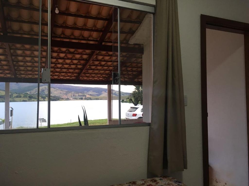 卡皮托利乌Suite independente em casa de fazenda的客房设有湖景窗户。