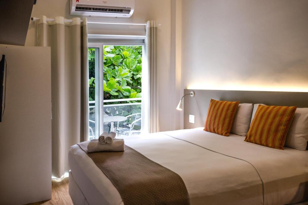 里约热内卢伊帕内玛殷乔伊公寓式酒店的一间卧室设有一张大床和一个窗户。