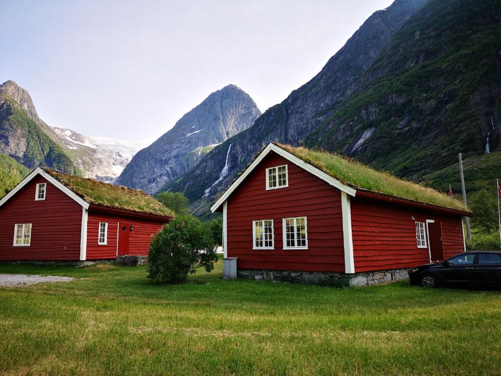 BriksdalsbreTrollbu Aabrekk gard的两个红色谷仓,在山前有草屋顶