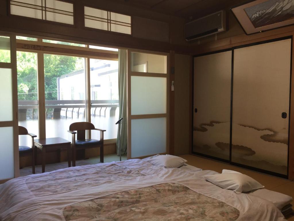 山之内町大丸屋日式旅馆的一间卧室设有一张床和一个大窗户