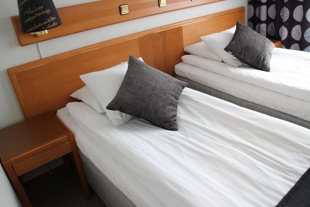 维纳什堡Arena Hotell的两张位于酒店客房的床,配有枕头